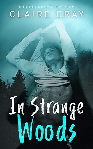 Book cover for IN STRANGE WOODS by Claire Cray. Superimposed over a foggy, dark blue-green treeline, a young man with his eyes closed and his head tilted back peels off a long-sleeved white shirt, exposing his torso.