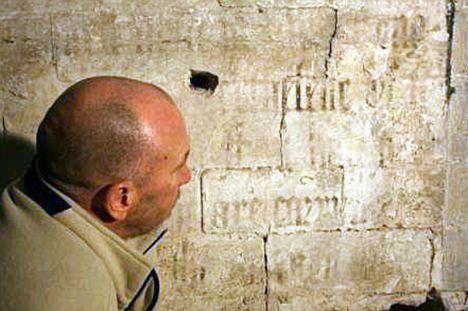 Conservator Tom Beattie examines the lettering