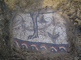 The uncovered section of the mosaic reveals intricate floor tiles which show the leg of an animal