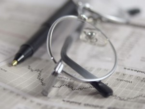 Eyeglasses, newspaper and pen