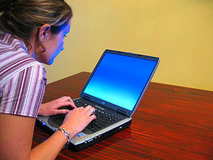 A woman typing on a laptop