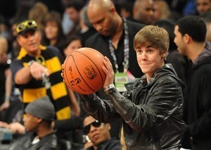 Singer Justin Bieber prepares to return a ball...