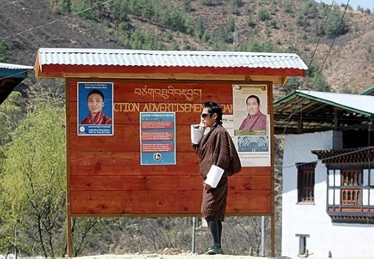 A Bhutanese man makes a cell-phone call as he stands beside an election campaign board displaying candidate posters in March 2008. (Deshakalyan Chowdhury/AFP/Getty Images)