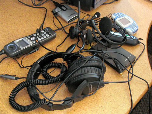 A jumble of wires, headphones, mobile phones, and gadgets