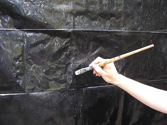 The Little Universe cover artist's arm with paintbrush