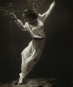 Fashion model underwater in dolphin tank, Mari...