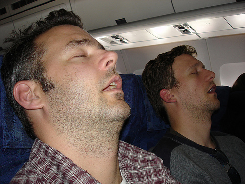 Two guys sleeping in a plane