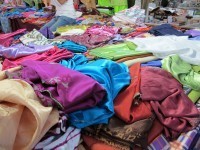 A pile of fabric at a market, bound for djellabas and caftans.