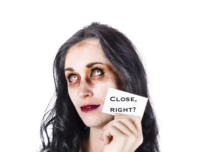 Face of a thoughtful zombie with business card