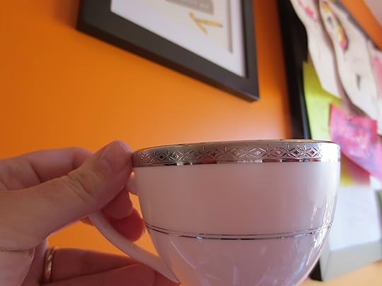 tea cup with steam against orange backdrop