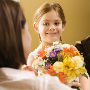 Girl giving mom flowers.