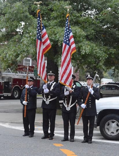 Firefighters in uniform holding flags