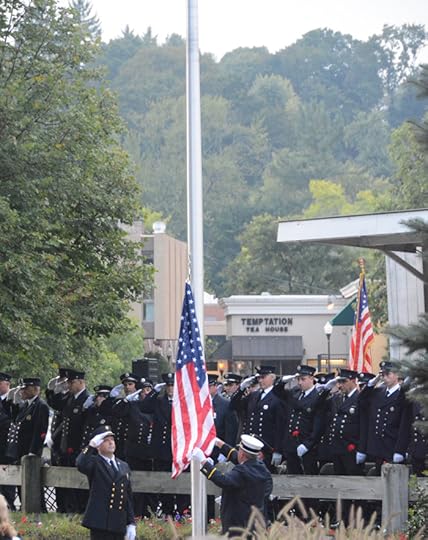 Flag at half mast with firefighters in uniform