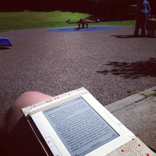 Trying to ignore my earlier stupidity by reading in the sun at the playground.