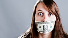 Young woman whose mouth is taped shut by a dollar bill