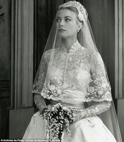 Wedding day: Kelly looks out from behind a satin veil in her elaborate wedding dress