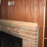 In process: building the new mantle; the mantle is held on by three lag screws and can be lifted off if necessary; the cove piece was shaped from a 1 x 4 run at an angle across a table saw blade -- it's one of a kind