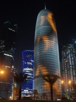 Pickle-shaped building on the corniche. The lights swirl all over it; looks like it's on fire.