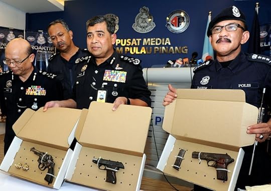 Khalid (middle) and Penang police chief Datuk Abdul Rahim Hanafi (right) showing reporters the pistols that were recovered at the apartment in Sungai Nibong
