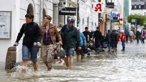 People with belongings they can carry hurry to escape the rising flood in Prague a day ago.