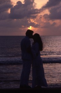 couple kissing at sunset by water