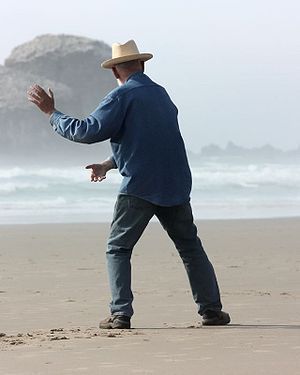 An elderly man performing tai chi in front of ...