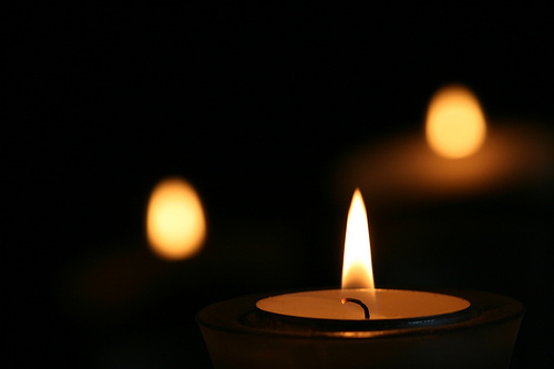 Candle in the right foreground with blurry candles in the background