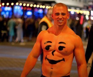 Muscular young man made up as the Kool-Aid pitcher.