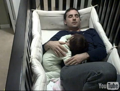 sleep deprived dad in crib with baby
