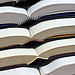 Several thick hardcover books stacked on top o...