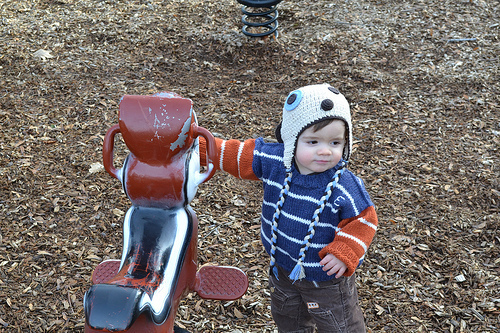Emile touching a playground bouncy horse