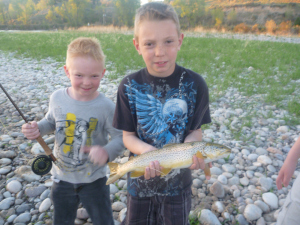 Big brother Dreyden poses with Skyler's big brown trout.