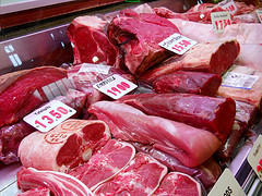 sides of raw beef at a grocery store meat isle
