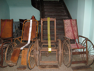 A collection of antique wheelchairs.
