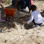 Kids uncovering a skeleton in the sand