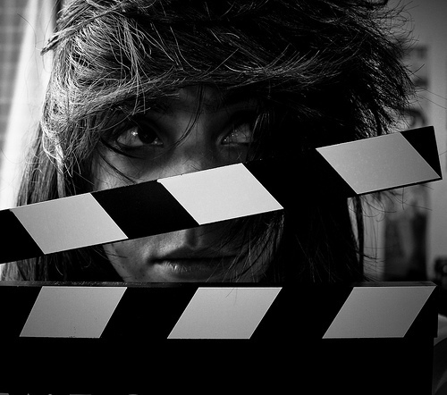Girl posing with a movie clapperboard