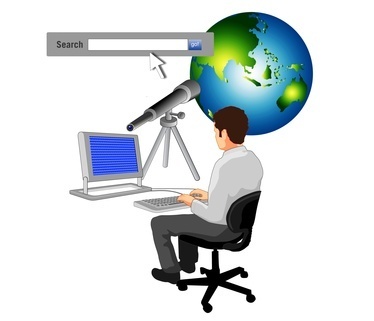 man sitting at computer looking at the world