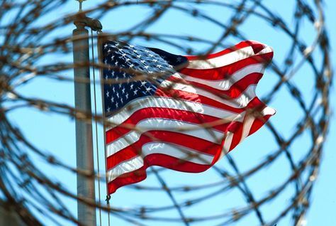 The US flag, seen through barbed wire, at Guantanamo.