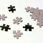 Scattered puzzle pieces next to solved fragment