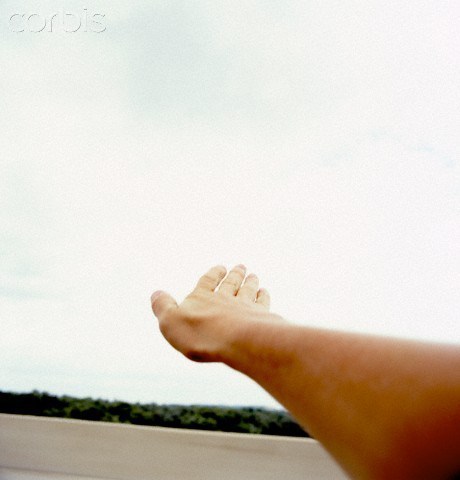 Man's arm sticking out of window of moving car
