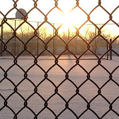 Snowy tennis courts through a fence at BHS. #blacksburgsnow