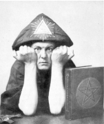 Aleister Crowley in A.'.A.'. regalia making the sign 
