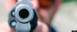 Guns; robbery. A man points a handgun directly at the camera.