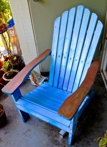 Picture of a blue Adirondack chair with copper arms.