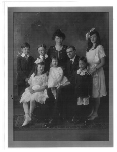 My grandfather on the right with his eldest sister's hands on his shoulder.