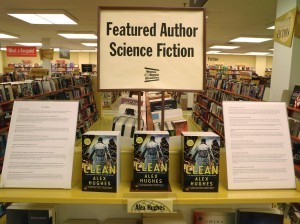 Three books in a row under a sign that says 