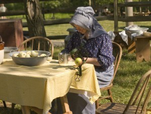A festival participant prepares apples for drying