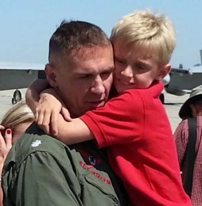 Commander Tommy Locke being hugged by his son, Jake