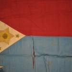 An extremely rare example of an early Philippine Revolutionary flag, made of cotton and silk, and depicting a hand-painted mythical sun with a face, a symbol common to several former Spanish colonies. Based on an crude inscription along the back border, the flag was captured by Corporal Alden Carpenter, 39th Infantry, after an engagement with Filipino forces at Lipa, Batangas on January 14, 1900.