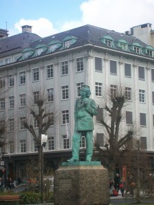 Edvard Greig statue under greenygrey roof.